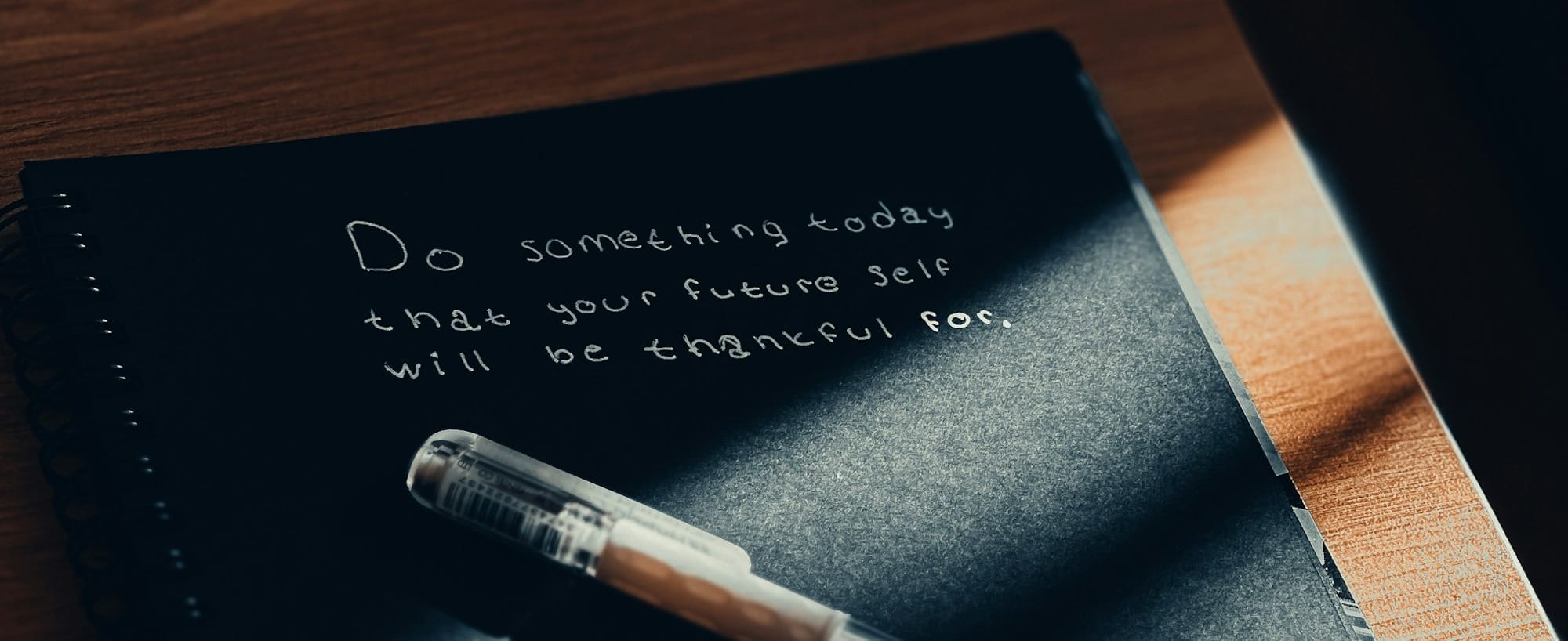 A notebook with a pen sitting on top of it